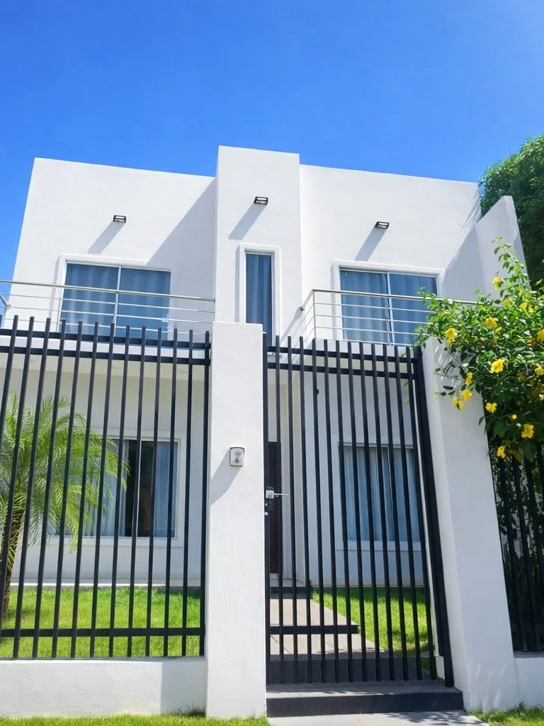 Vivienda blanca terminada, vista desde el portón